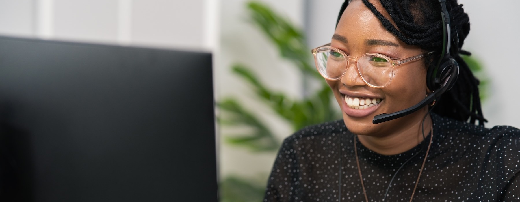 a woman smiling at a computer