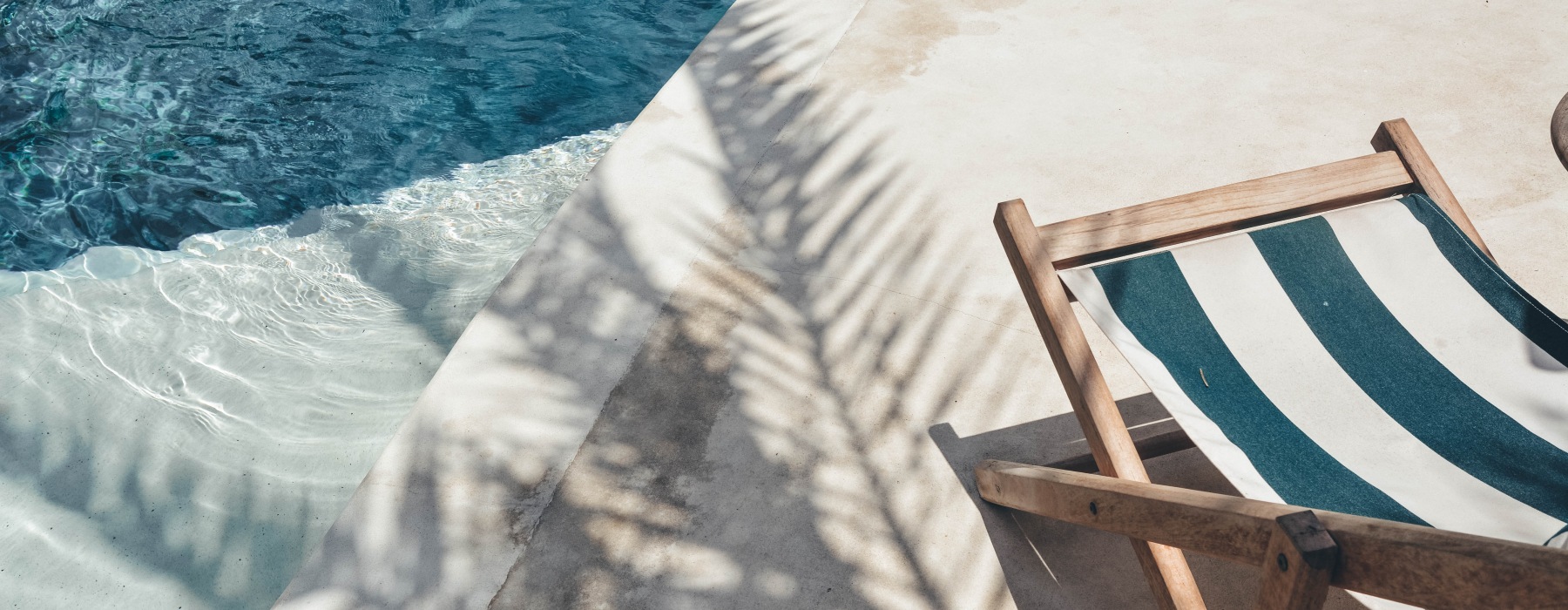 Stripped chair next to a swimming pool