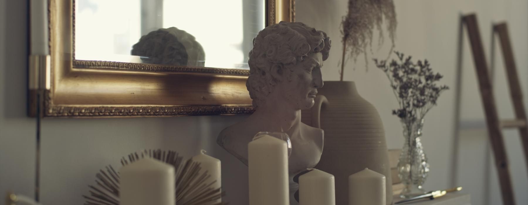 a head bust on a table with candles
