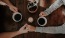 Couple holding holding hands while drinking coffee